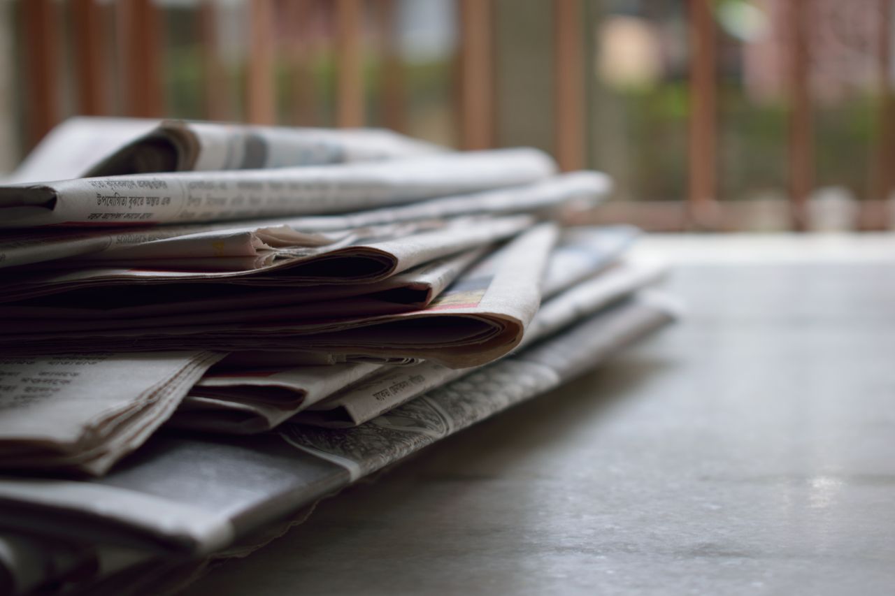 Crafting Captivating Headlines: Your awesome post title goes here A close-up of a stack of newspapers resting on a desk, symbolizing information and media.