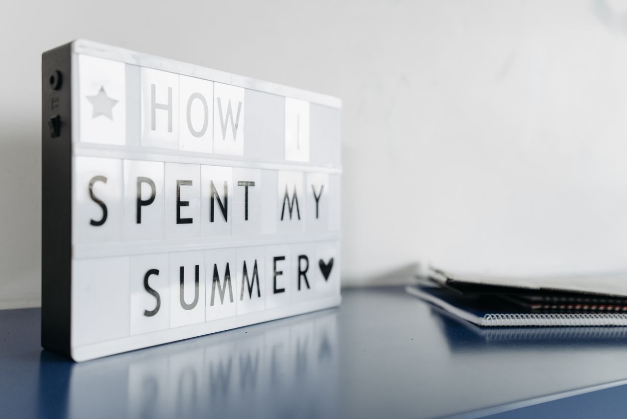 Offerings Close-up of a lightbox with 'How I Spent My Summer' text on a desk.